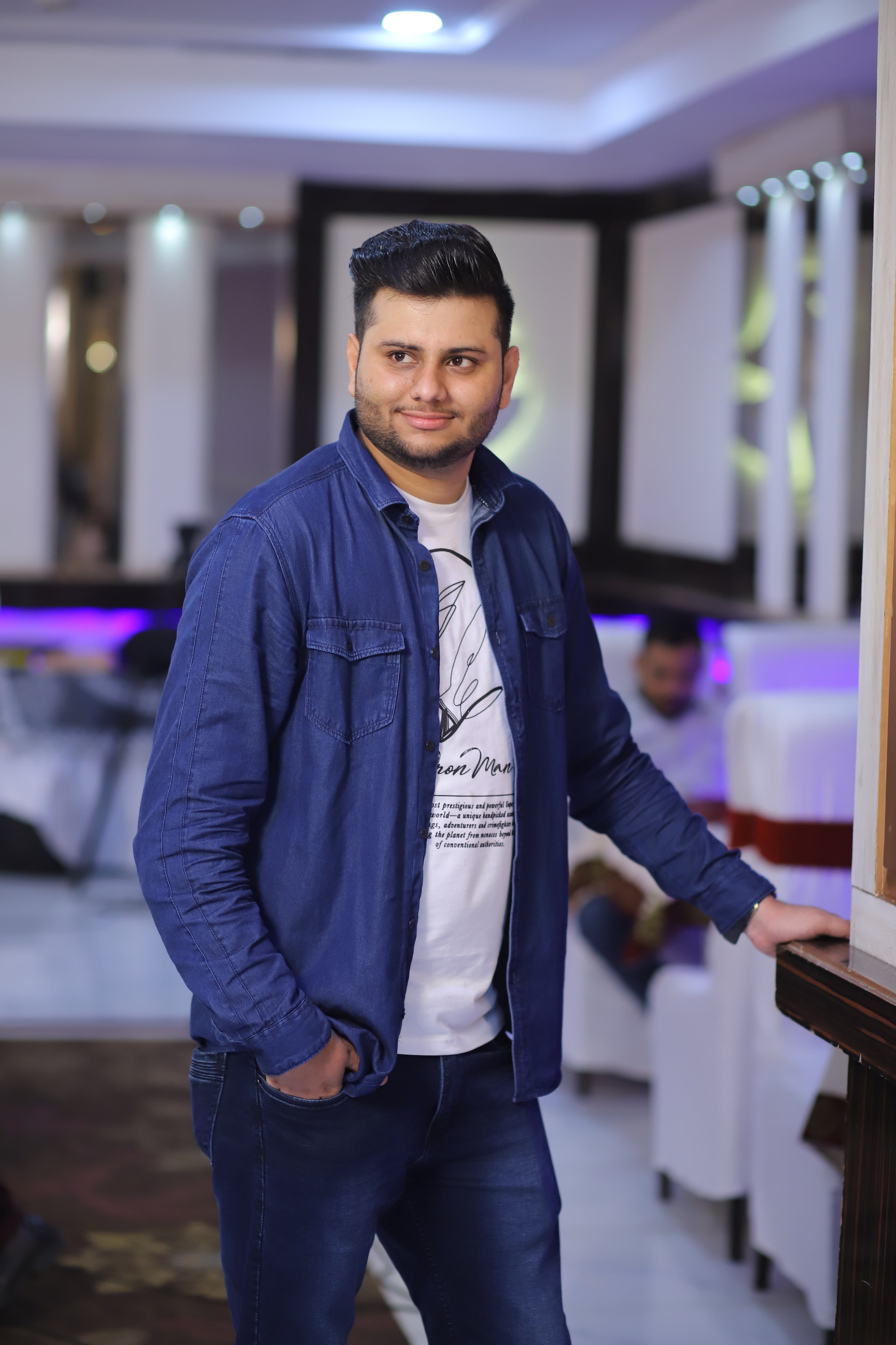 Shubham Verma in a denim shirt over a graphic tee at an indoor venue